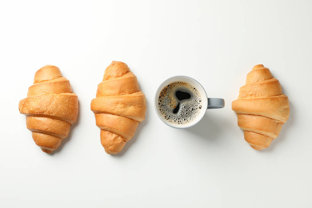 Vlak gelegd met croissants en kopje koffie op witte achtergrond,  - Foto, afbeelding