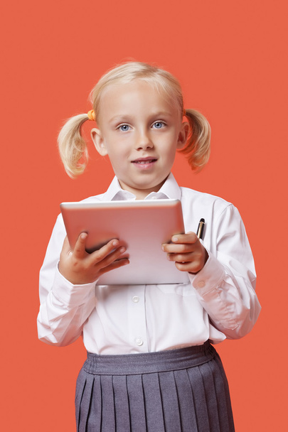 Schoolgirl holding tablet PC - Foto, afbeelding