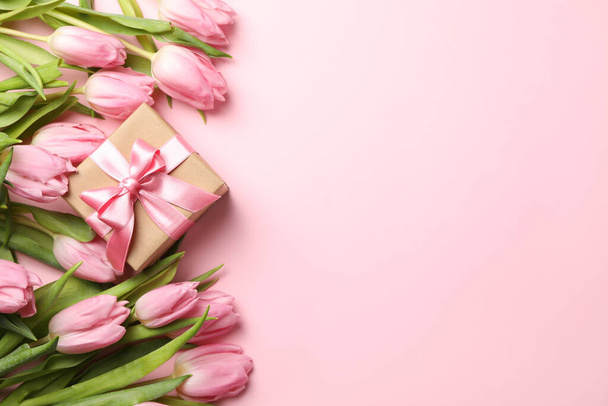 Beautiful tulips and gift box on pink background, top view - Foto, imagen