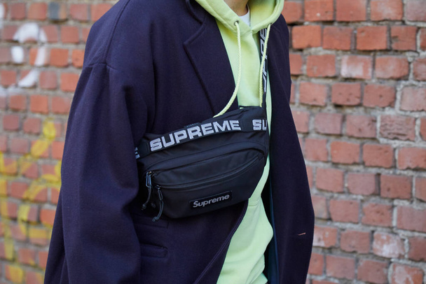Man with black Supreme pouch and yellow green hoodie before Fendi fashion show, Milan Fashion Week street style - Photo, Image