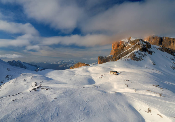 Εναέρια, πανοραμική θέα το χειμώνα στην όμορφη τουριστική καλύβα βουνό. Δολομίτες ορειβατικό τοπίο από ψηλά. Pale di San Martino οροσειρά, καλυμμένη με χιόνι. Rosetta, San Martino di Castrozza, Ιταλία. - Φωτογραφία, εικόνα
