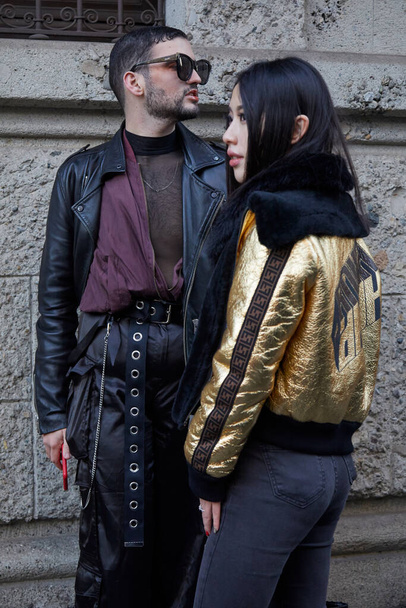 Man with black satin trousers and woman with golden Fendi jacket before Reshake fashion show, Milan Fashion Week street style - Foto, imagen