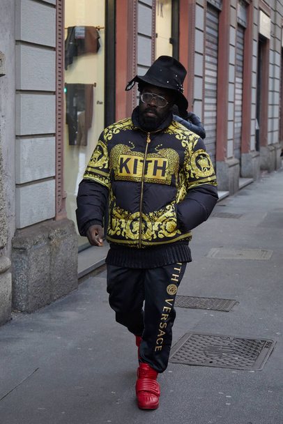 Man with Kith x Versace black jacket and trousers with golden design before Reshake fashion show, Milan Fashion Week street style - Foto, Imagen