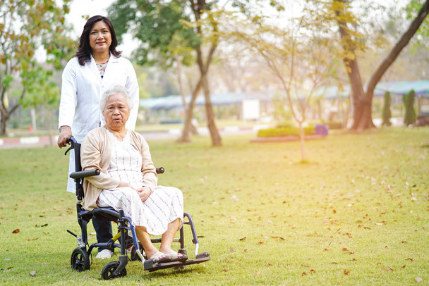 Lääkäri apua ja hoitoa Aasian vanhempi tai vanhusten vanha nainen nainen potilas istuu pyörätuolilla hoitotyön sairaalassa: terve vahva lääketieteellinen käsite
 - Valokuva, kuva
