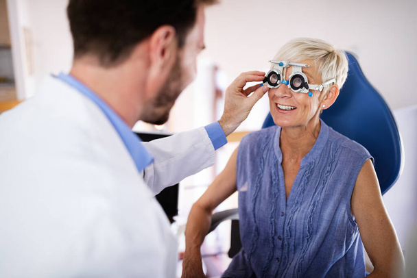 Ophthalmology concept. Senior woman eye vision examination in ophthalmological clinic - Photo, image