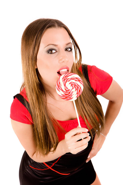 Provocative woman licking colorful lollipop. - 写真・画像