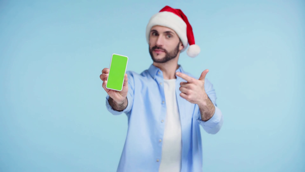 focus pull of man holding smartphone with green screen isolated on blue  - Footage, Video