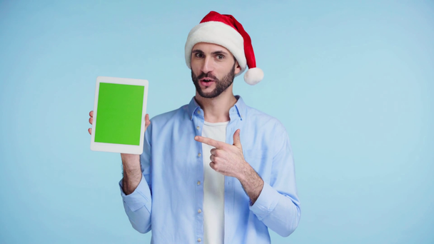 Yeşil ekranlı dijital tablet tutan adam mavi ekranda izole edilmiş. - Video, Çekim