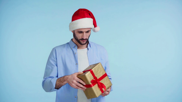 man in santa hat catching gift isolated on blue - Footage, Video