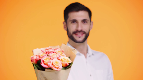 Rack Fokus des Mannes mit Blumen isoliert auf orange - Filmmaterial, Video