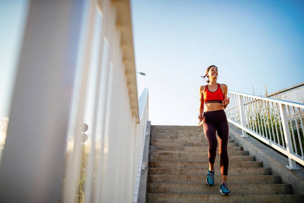 Happy young fit woman exercising outdoors. Living healthy life - Fotó, kép