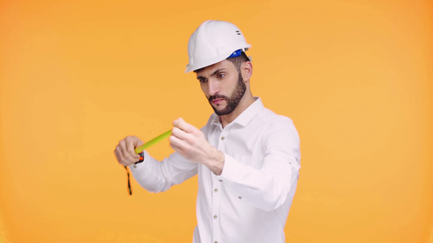 architect looking at measuring tape isolated on orange  - Footage, Video