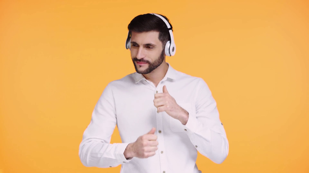 άνθρωπος με ακουστικά που χορεύει απομονωμένος σε πορτοκαλί   - Πλάνα, βίντεο