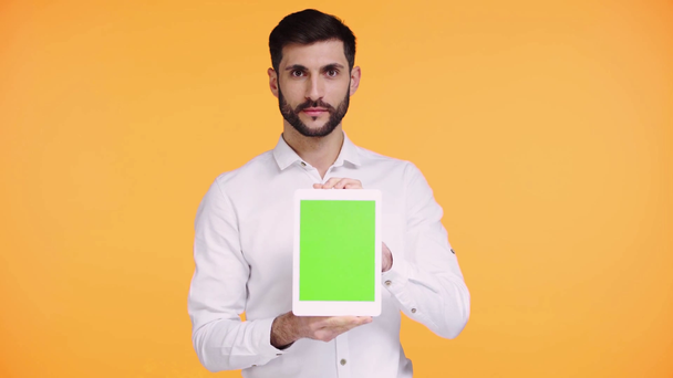 homem segurando tablet digital com tela verde isolado em laranja
  - Filmagem, Vídeo