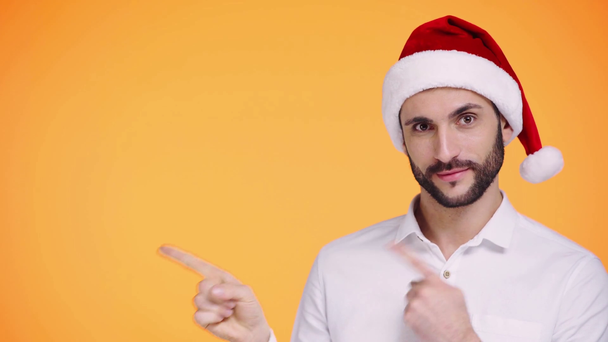 Mann mit Weihnachtsmütze zeigt mit Fingern auf orange  - Filmmaterial, Video