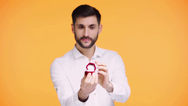 мужчина держит обручальное кольцо изолированы на оранжевый
  - Кадры, видео