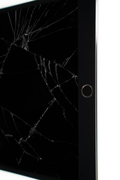Geïsoleerde tablet met gebroken beeldscherm, gebarsten netvlies scherm op witte achtergrond - Foto, afbeelding