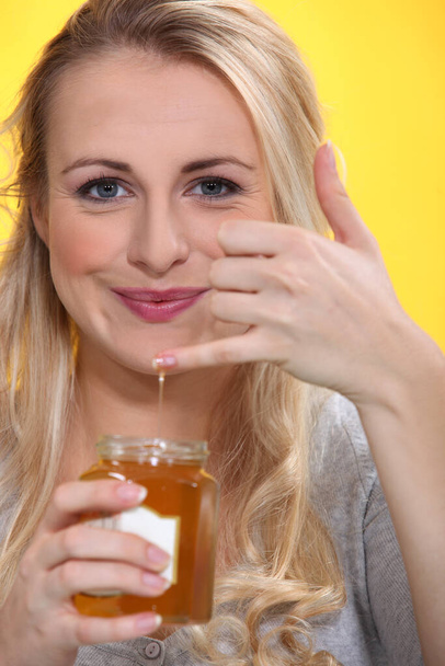 Smiling woman holding a honeypot - Foto, Imagen