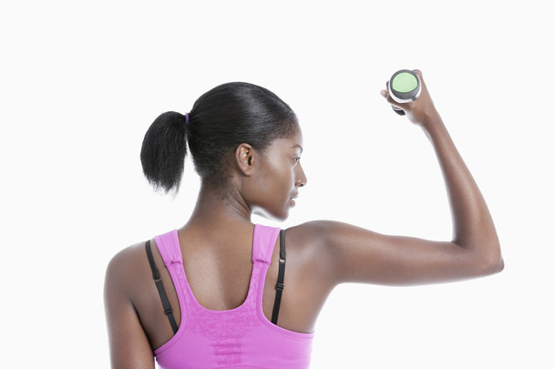 Young woman raising dumbbell - Photo, image