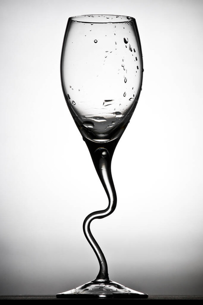 curved wineglass contrast with drops against white background - Valokuva, kuva