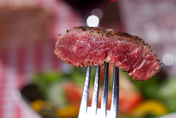 steak on a fork over salad - Fotografie, Obrázek