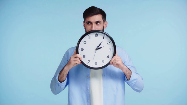 ευτυχισμένος άνθρωπος κρατώντας ρολόι απομονώνονται σε μπλε - Πλάνα, βίντεο