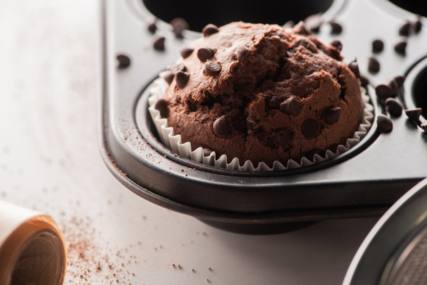 close up view of fresh chocolate muffin in muffin tin - Фото, изображение