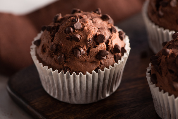 close up view of fresh chocolate muffin on wooden cutting board - 写真・画像