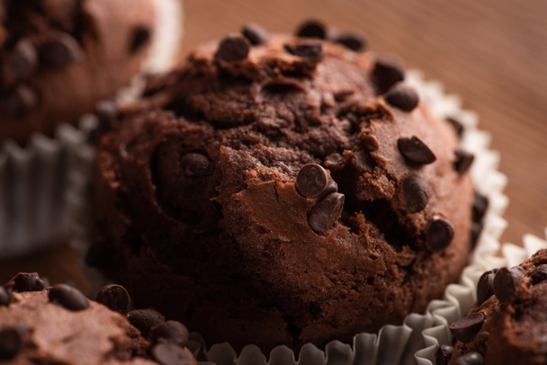 close up view of fresh chocolate muffin on wooden surface - Fotoğraf, Görsel