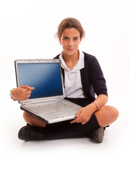 Schoolgirl sitting on the floor with an open laptop - Fotoğraf, Görsel
