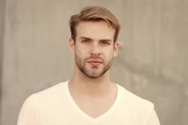Handsome caucasian man gray background. Bearded guy casual style close up. Male beauty standards. Ideal traits that make man physically attractive. Handsome man unshaven face stylish hairstyle - Foto, Imagem