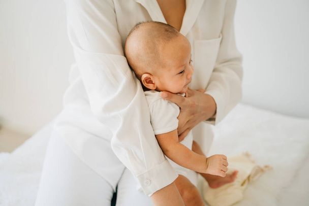 Maman avec bébé asiatique sur les jambes
 - Photo, image