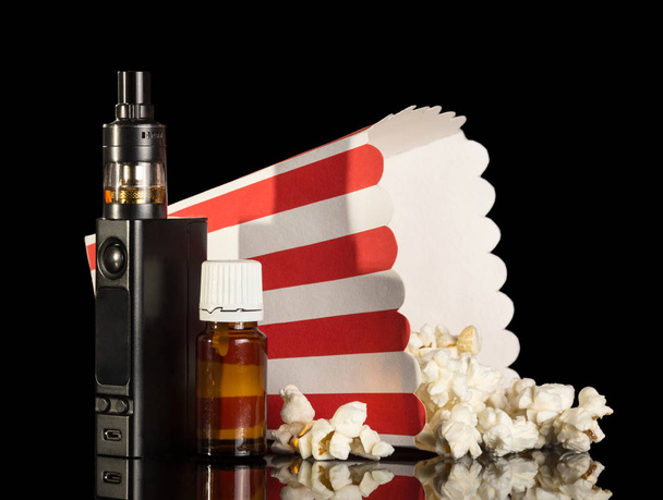 Electronic cigarette and liquid with the taste of popcorn isolated on black - Fotoğraf, Görsel