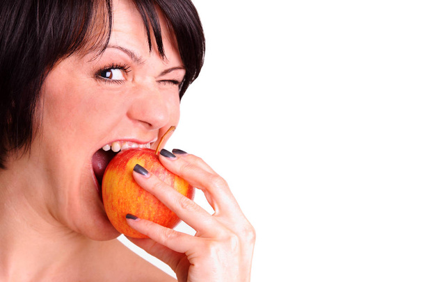 young woman is biting into apple - Фото, зображення