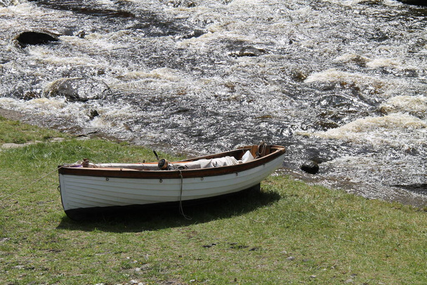 川岸に係留されている小型帆船. - 写真・画像
