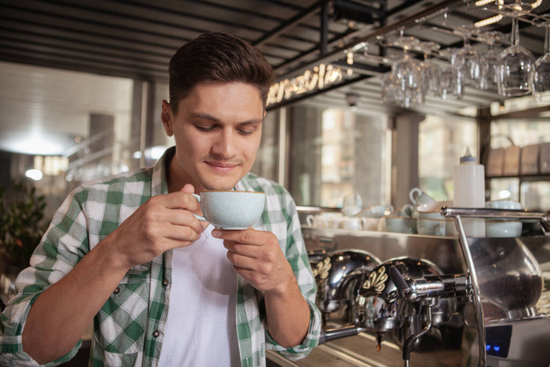 Knappe mannelijke barista werkt in de coffeeshop - Foto, afbeelding