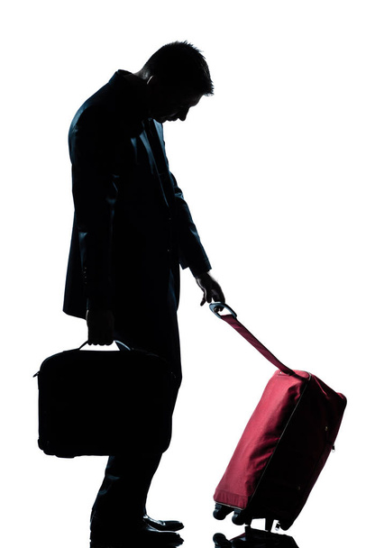 side view one caucasian business traveler man tired with suitcase  full length silhouette in studio isolated white background - Foto, immagini