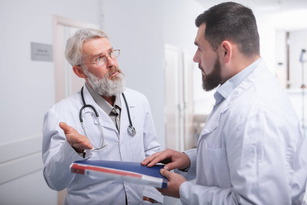 Médico senior hablando con un colega en el hospital
 - Foto, Imagen