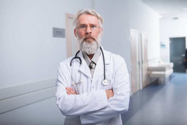 Elderly male doctor at his clinic - Foto, Imagen