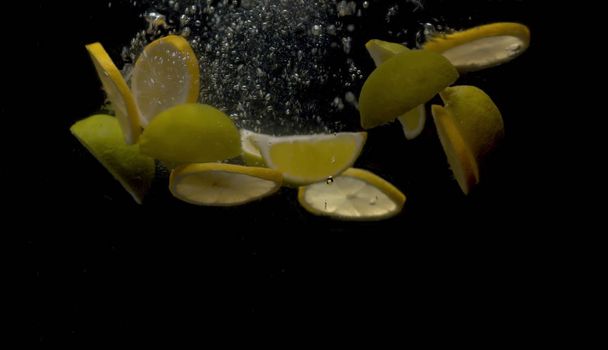 Sliced lemons falling into the water - Photo, Image