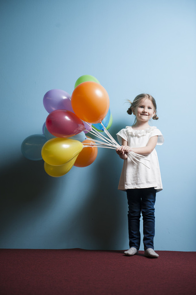 Girl holds bunch of balloons - Фото, изображение