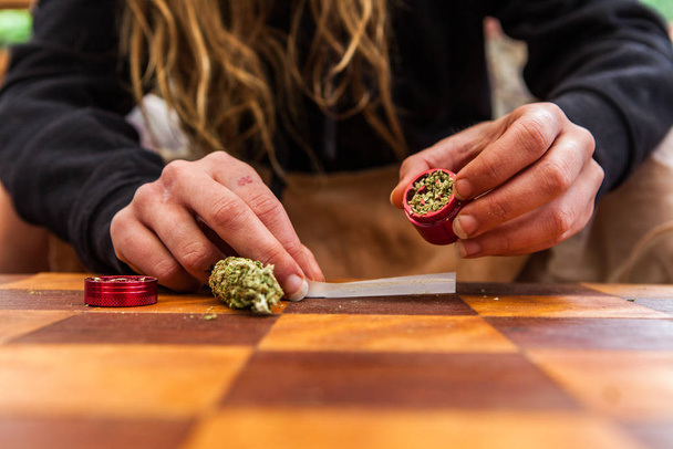Рука раскатывает марихуану с нуля
 - Фото, изображение