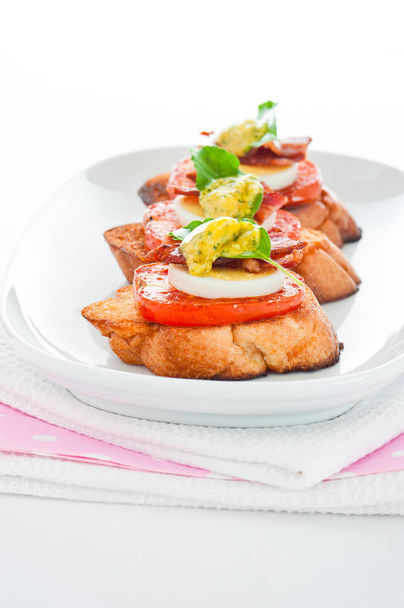 A baguette slice with tomato egg bacon and herb butter - Foto, Bild