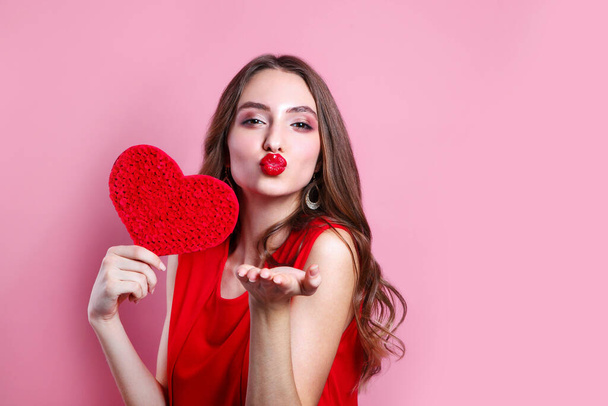 Sexy woman blowing a kiss from her hand. Woman with heart shaped . Perfect make up with red lips. Send kiss. - Fotografie, Obrázek