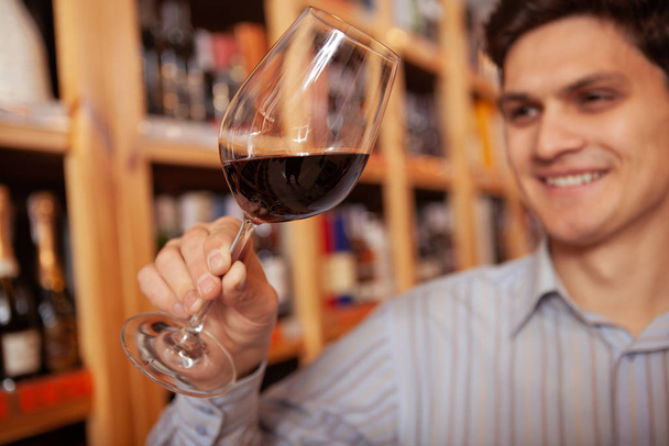 Handsome young man shopping at wine store - Foto, imagen