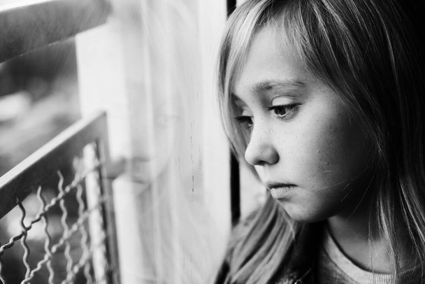 Ritratto di una ragazza triste di 9 anni seduta accanto a un vento
 - Foto, immagini