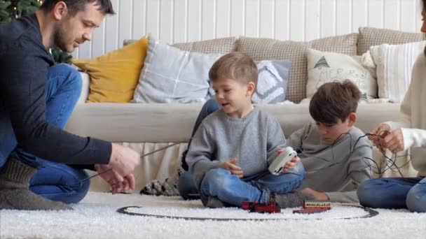 Familie baut an Heiligabend zu Hause gemeinsam ein Gleis - Filmmaterial, Video