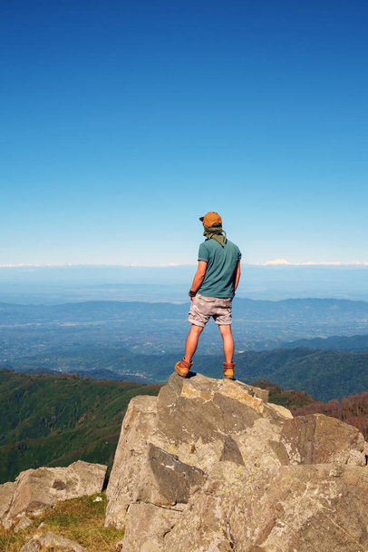 Jonge reiziger staat op de top van de berg met klif  - Foto, afbeelding