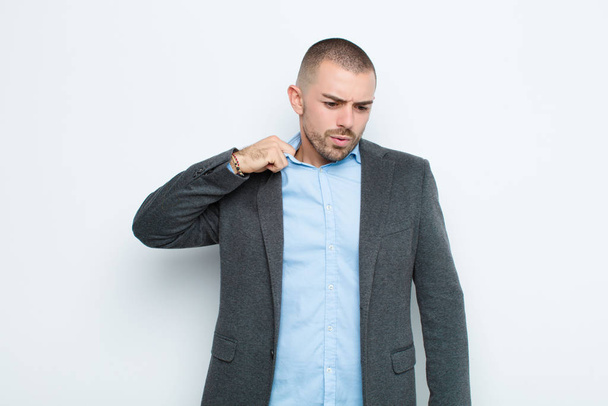 young businessman feeling stressed, anxious, tired and frustrated, pulling shirt neck, looking frustrated with problem against flat wall - Foto, Imagem