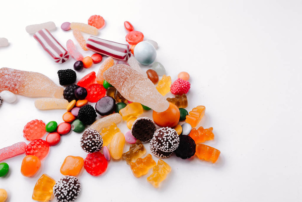 Concept no sweets, colorful candies, jelly and marmalade on white background. Flat lay, top view - 写真・画像